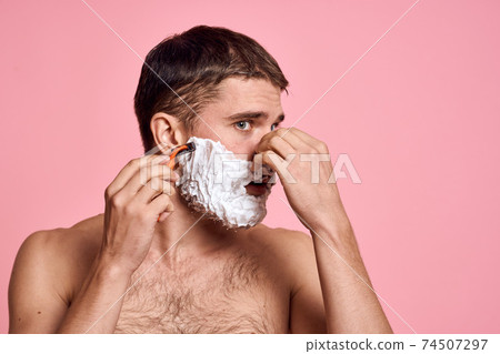 man with razor and white foam on his face pink background nude torso bathing treatments man with razor and white foam on his face pink background nude torso bathing treatments 74507297