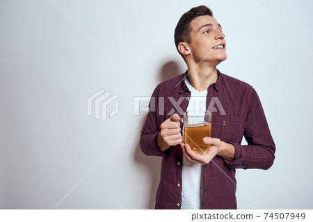 Cheerful man with mug of beer alcohol emotions light background Cheerful man with mug of beer alcohol emotions light background 74507949