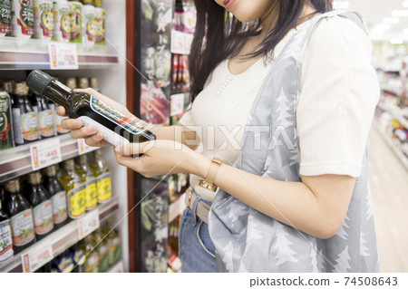 女顧客在一家超市撿橄欖油 74508643