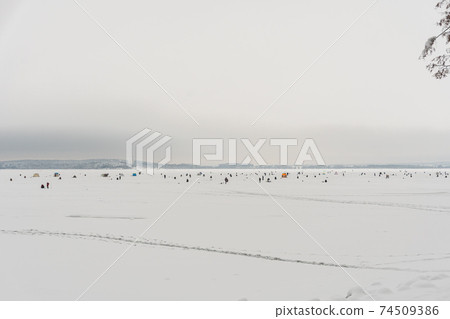 Winter fishing championship in Belarus, thousands of fishermen on ice in winter Winter fishing championship in Belarus, thousands of fishermen on ice in winter 74509386