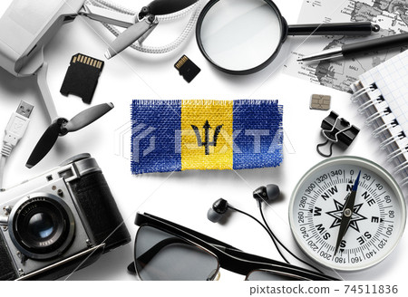 Flag of Barbados and travel accessories on a white background. 74511836
