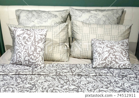Set of different-sized pillows on neatly made bed. Bedroom interior 74512911