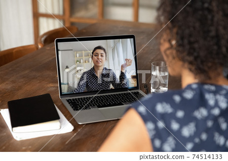 Back view African American woman making video call to colleague Back view African American woman making video call to colleague 74514133