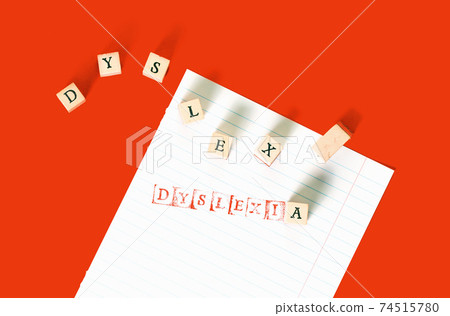 Dyslexia word stamped on notebook page on red 74515780