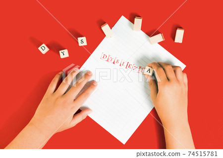Dyslexia word stamped on notebook page on red 74515781