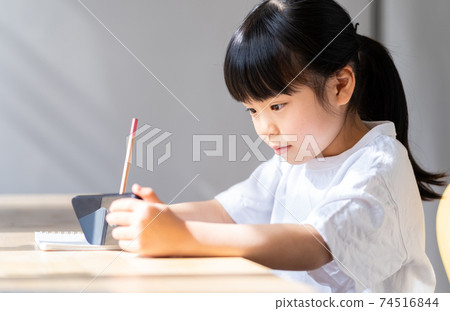 Elementary school girl studying on a smartphone 74516844