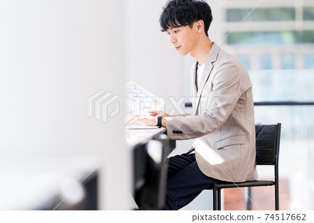 工作在辦公室的一個年輕商人 74517662