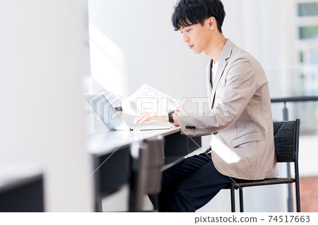 工作在辦公室的一個年輕商人 74517663