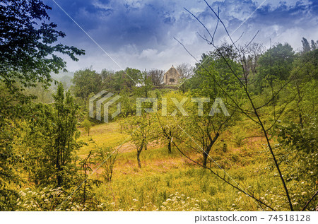 landscape in a midi pyrenees forest with a chapel on top of a hill. Lot department. France. 74518128