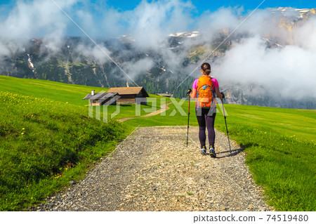 Sporty woman with backpack on the hiking trail, Dolomites, Italy Sporty woman with backpack on the hiking trail, Dolomites, Italy 74519480