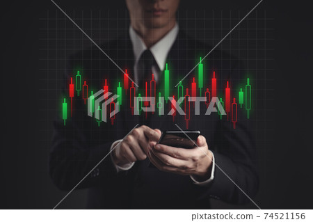 Businessman using smartphone showing candlestick chart hologram effect. Businessman using smartphone showing candlestick chart hologram effect. 74521156