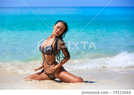 Sexy girl posing in the sunny day at the tropical beach Sexy girl posing in the sunny day at the tropical beach 74522668