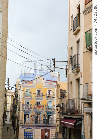 巴塞羅那郊區塔拉戈納的城市景觀，在一條建築小巷兩側的西班牙公寓，上面有公寓居民的照片 74523386