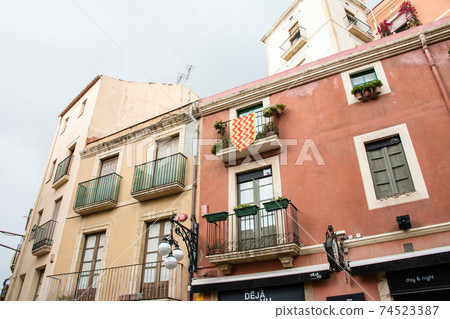 Cityscape of Tarragona, a suburb of Barcelona, Spain Light brown wall building with flowerpots by the window Cityscape of Tarragona, a suburb of Barcelona, Spain Light brown wall building with flowerpots by the window 74523387