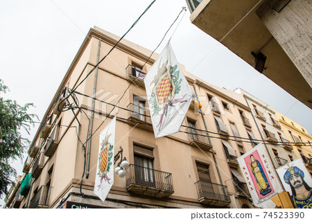 Cityscape of Tarragona, a suburb of Barcelona, Spain Building with banners and light brown walls on the street Cityscape of Tarragona, a suburb of Barcelona, Spain Building with banners and light brown walls on the street 74523390