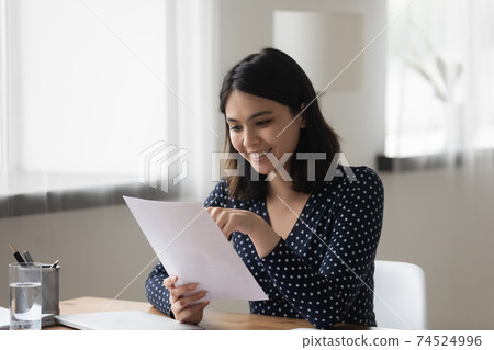 Smiling asian female review paper report satisfied with good results Smiling asian female review paper report satisfied with good results 74524996