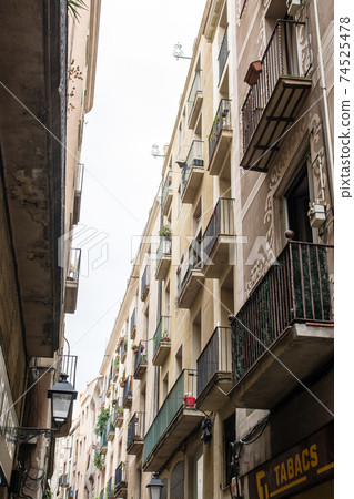 The streets of Tarragona, a suburb of Barcelona, Spain, apartments lined up on both sides of a narrow path The streets of Tarragona, a suburb of Barcelona, Spain, apartments lined up on both sides of a narrow path 74525478