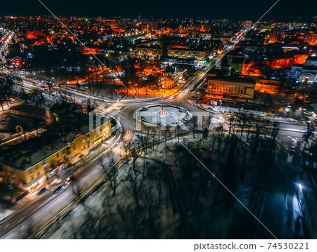 Night aerial view of roundabout road with circular cars in small european city Night aerial view of roundabout road with circular cars in small european city 74530221