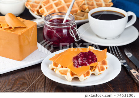 Homemade waffles with norwegian brown cheese and lingon jam, on wooden background, horizontal 74531003