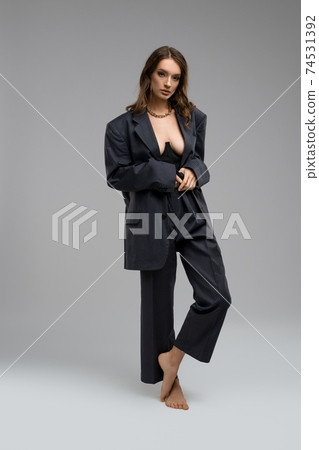 Sexy woman in suit and corset in studio - Stock Photo [74531392]