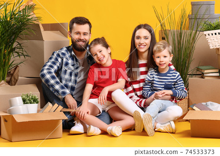 Cheerful family unpacking belongings in new house 74533373