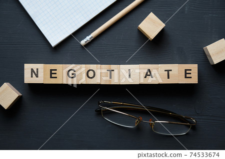Modern business buzzword - negotiate. Top view on wooden table with blocks. Top view. 74533674