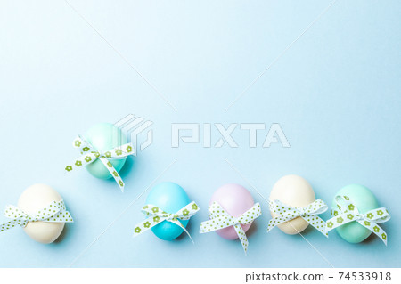 Easter background blue. Colourful egg with tape ribbon on pastel blue background in Happy Easter decoration. Flat lay, top view. Easter background blue. Colourful egg with tape ribbon on pastel blue background in Happy Easter decoration. Flat lay, top view. 74533918