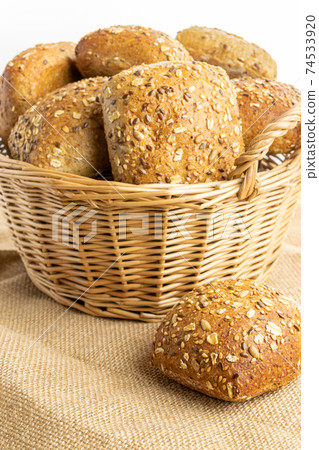 Cut bread. Fresh loaf of rustic traditional bread with wheat grain ear or spike plant on linen texture background. Rye bakery with crusty loaves and crumbs. Bio ingredients, very healthy seeds. Cut bread. Fresh loaf of rustic traditional bread with wheat grain ear or spike plant on linen texture background. Rye bakery with crusty loaves and crumbs. Bio ingredients, very healthy seeds. 74533920