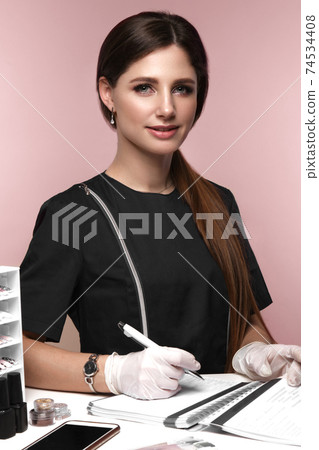 Manicurist in working form with tools in hand. Nail photo content Manicurist in working form with tools in hand. Nail photo content 74534408