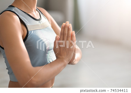 Cropped of sporty woman holding hands in namaste gesture Cropped of sporty woman holding hands in namaste gesture 74534411