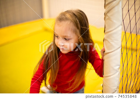 Girl on trampoline at indoor play center 74535848