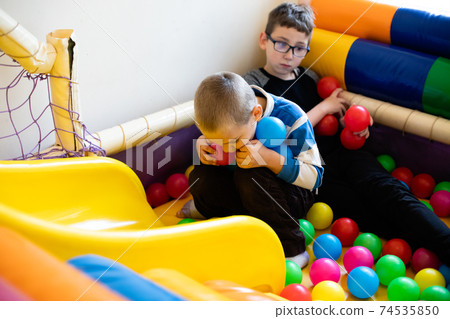 Boys play in pool with soft plastic balls Boys play in pool with soft plastic balls 74535850