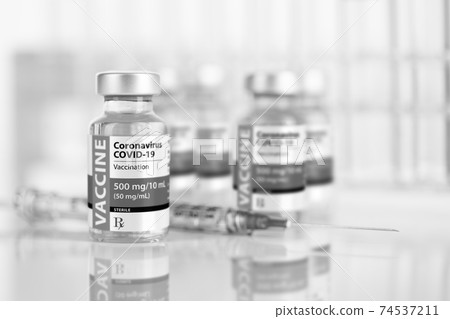 Coronavirus COVID-19 Vaccine Vials and Syringe On Reflective Surface 74537211