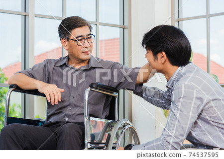 old man in a wheelchair and his young son 74537595