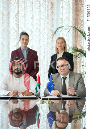 Confident intercultural business partners or delegates and elegant businesswomen Confident intercultural business partners or delegates and elegant businesswomen 74539303