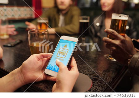 Hand of young woman with smartphone over table going to call for taxi 74539315