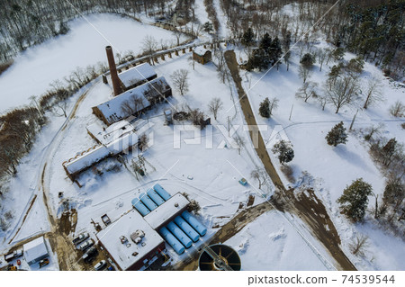 Aerial view of modern little industrial sewage treatment plant at work in winter season Aerial view of modern little industrial sewage treatment plant at work in winter season 74539544