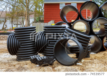 Plastic PVC pipes stacked in rows at a construction site on reconstruction of the city drain system Plastic PVC pipes stacked in rows at a construction site on reconstruction of the city drain system 74539577