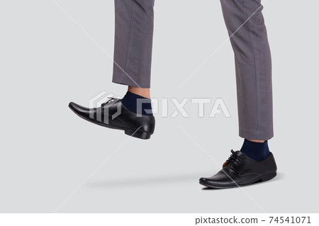 Foot of businessman walking for achievement isolated on white background. Foot of businessman walking for achievement isolated on white background. 74541071