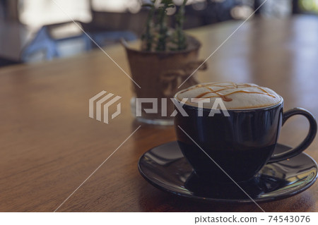 Close up hot cappuccino, latte, caramel macchiato on table with blur coffee shop background. Process with warm vintage tone style. Close up hot cappuccino, latte, caramel macchiato on table with blur coffee shop background. Process with warm vintage tone style. 74543076
