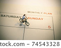 Girl riding bicycle with vintage weekend calendar 74543328