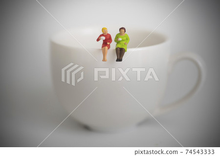 Two women sipping coffee together Two women sipping coffee together 74543333