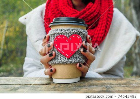 Close up cozy cup with heart shape in hand on the nature. Outdoor picnic good mood. Close up cozy cup with heart shape in hand on the nature. Outdoor picnic good mood. 74543482