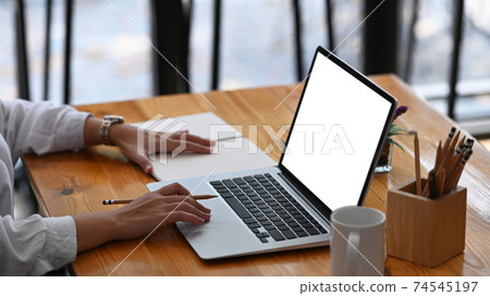 Cropped shot of young female hand typing on laptop computer at her workspace. 74545197
