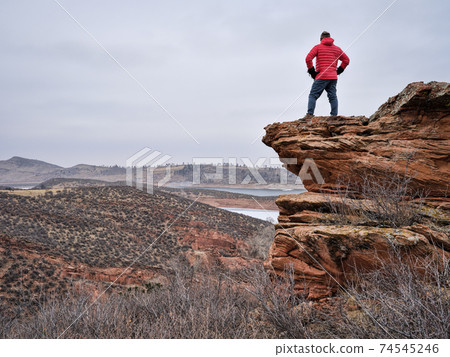 male hiker on a rocky cliff at foothills of Rocky Mountains male hiker on a rocky cliff at foothills of Rocky Mountains 74545246