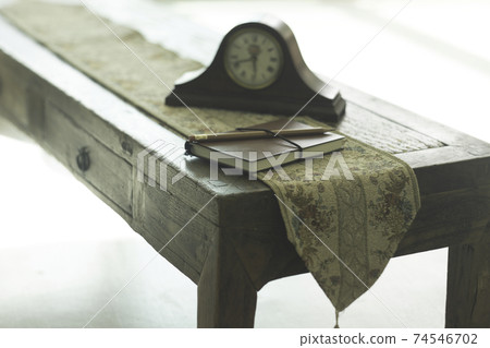 Table with table clock and notebook 74546702