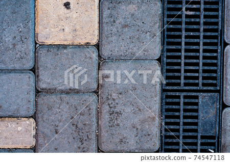 Paving slabs close up, metal drain grate, textured background 74547118
