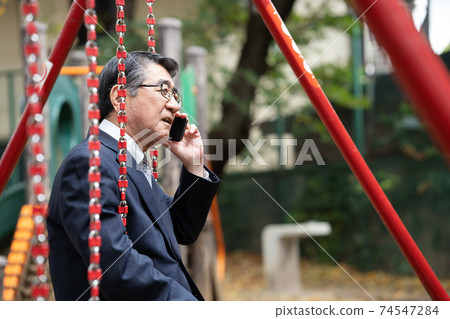 Businessman making a phone call Park swing 74547284