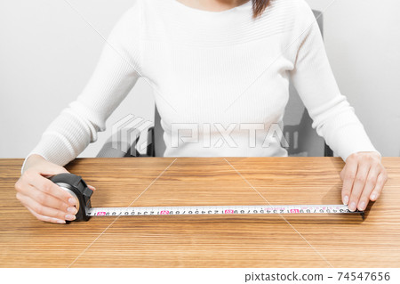 坐在女人用捲尺測量 坐在女人用捲尺測量 74547656