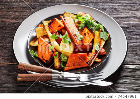Moroccan roasted parsnip and carrot on a plate 74547961